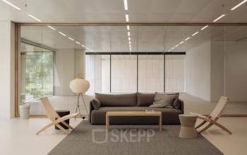 Modern office to rent featuring a cozy seating area with a sofa and chairs, ideal for meetings. Located in Amsterdam West, offering excellent office space rental opportunities.