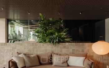 Cozy and modern lounge area with seating and table, ideal for office space rental at Nachtwachtlaan 20, Amsterdam West.