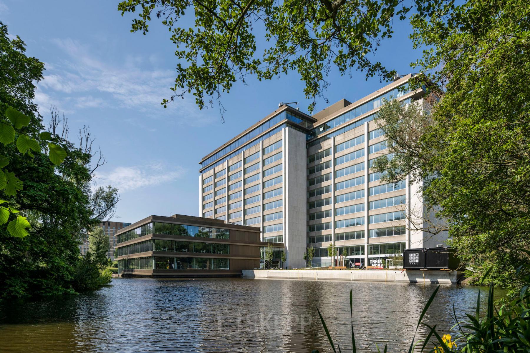 Modern office building at Nachtwachtlaan 20, Amsterdam West, featuring large windows and surrounded by greenery, ideal for office space rental.