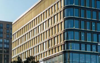 Modern office building at Kon. Wilhelminaplein 4, Amsterdam West, available for rent office space with large glass windows and a sleek exterior design.