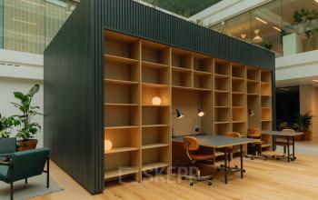 Modern office space with wooden floors featuring open shelving and desks for rent at Kon. Wilhelminaplein 4, Amsterdam West.