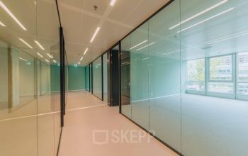 Spacious office space at Kon. Wilhelminaplein 4, Amsterdam West with glass partitions and natural light, ideal for office space rental.
