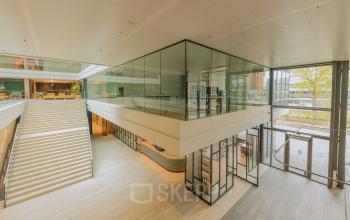 Spacious interior view of an office space at Kon. Wilhelminaplein 4, Amsterdam West, showcasing modern architecture and natural light. Ideal for office space rental.