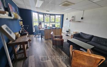 Office space at Gyroscoopweg 23-25, Amsterdam Westpoort featuring desks, chairs, a couch, and large windows with natural light, suitable for office space rental.