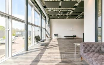 Bright open space with large windows and modern furniture at Poortland 242, Amsterdam Westpoort, ideal for office space rental.