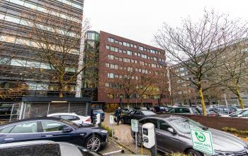 Exterior view of office building at Hullenbergweg 278, Amsterdam South East, featuring a large parking area. Ideal for office space rental.