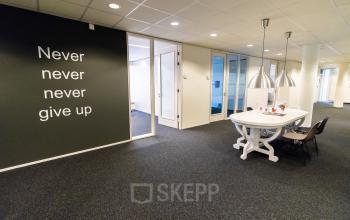 Bright office space at Hullenbergweg 278 in Amsterdam South East featuring motivational wall art and a furnished meeting area, perfect for rent office activities.