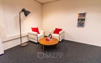 Cozy office space at Hullenbergweg 278 in Amsterdam South East with two armchairs, a wooden coffee table, and a floor lamp, ideal for office space rental.