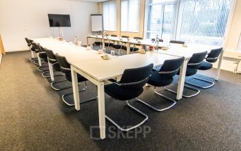 Bright and spacious conference room available for office space rental at Hullenbergweg 278, Amsterdam South East, featuring a large meeting table, chairs, and presentation equipment.