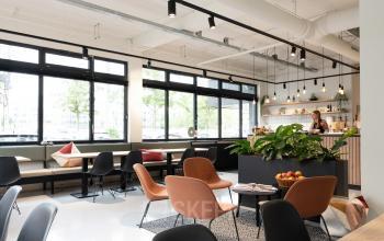 Modern office space rental at Hogehilweg 19, Amsterdam South East, with stylish furnishings and large windows offering ample natural light.