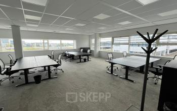 Spacious office at Laarderhoogtweg 7-19, Amsterdam South East, available for rent. Furnished with modern desks and chairs, ideal for collaborative work. Large windows offer ample natural light.