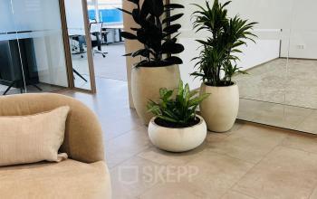 Modern office lobby at Laarderhoogtweg 7-19, Amsterdam South East, featuring stylish seating and indoor plants. Ideal office space rental opportunity.
