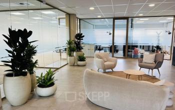 Stylish office space rental in Amsterdam South East with modern furnishings, including comfortable seating and greenery, ideal for meetings or collaborative work.