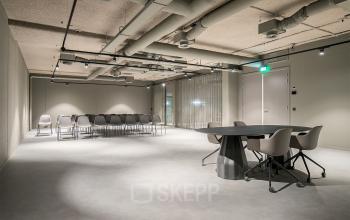 Spacious office at De Entree 201, Amsterdam South East, featuring a modern open floorplan with chairs arranged for events, ideal for office space rental.