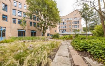 Exterior view of an office building with a garden at Bijlmerplein 888, Amsterdam South East, showcasing the opportunity for office space rental.