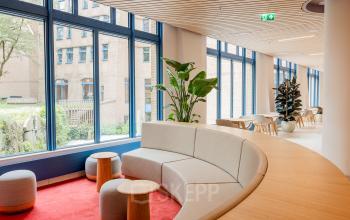 Spacious, modern office lounge with stylish seating and large windows at Bijlmerplein 888, Amsterdam South East, ideal for office space rental.