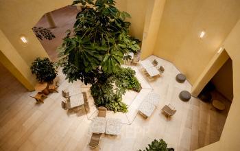 Bright office space rental at Bijlmerplein 888, Amsterdam South East, featuring modern seating and lush greenery.