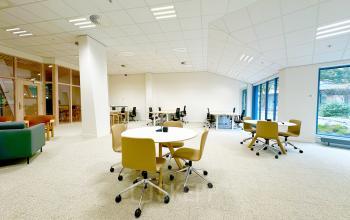 Modern office space for rent at Bijlmerplein 888, Amsterdam South East, featuring spacious workspaces with chairs, tables, and large windows offering natural light.
