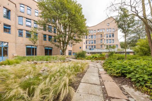 Exterior view of an office building with a garden at Bijlmerplein 888, Amsterdam South East, showcasing the opportunity for office space rental.