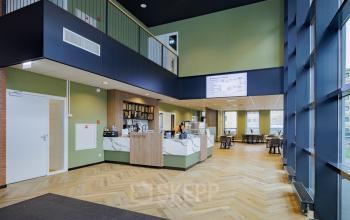 Bright and modern reception area with wooden flooring and ample natural light at Hogehilweg 24, Amsterdam South East. Ideal for office space rental with open and welcoming surroundings.