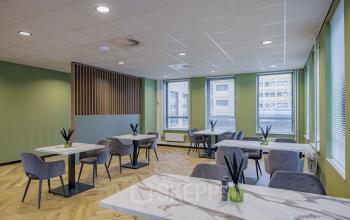 Modern office space at Hogehilweg 24 with stylish tables and chairs, perfect for casual meetings or work breaks in Amsterdam South East.