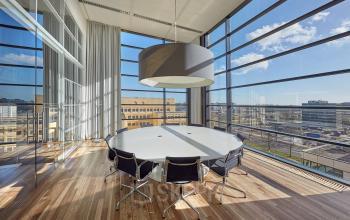 Bright and modern office space rental at Hogehilweg 24 in Amsterdam South East with a large conference table surrounded by stylish chairs and panoramic windows.