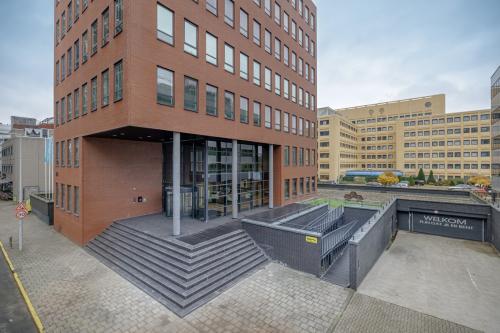 Exterior view of office building at Hogehilweg 24, Amsterdam South East, showcasing modern architecture with brick facade and welcoming entrance steps. Ideal for office space rental in a bustling business area.