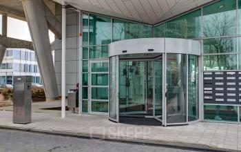 Exterior view of De Entree 230-266 in Amsterdam South East, showcasing the modern glass entrance of an office building available for rent.
