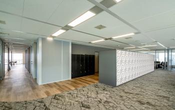 Modern office interior at De Entree 230-266, Amsterdam South East, featuring open workspaces with stylish flooring and natural light, ideal for office space rental.