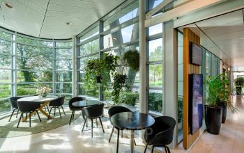 Bright and modern lounge area with large windows and ample natural light at De Entree 230-266, Amsterdam South-East. Perfect office space rental spot for informal meetings or relaxation.