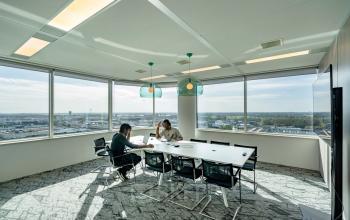 Bright conference room at De Entree 230-266, Amsterdam South East, featuring a long table, chairs, and panoramic windows. Ideal for office space rental.