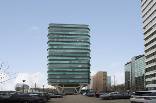 Exterior view of a modern office building with a unique design located at De Entree 230-266, in Amsterdam South East. The building offers potential office space rental opportunities.