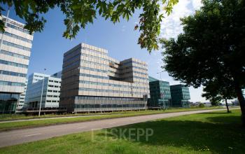 Modern office building located at Herikerbergweg 288 in Amsterdam South East, showcasing sleek glass architecture, ideal for those seeking office space rental in a dynamic urban setting.