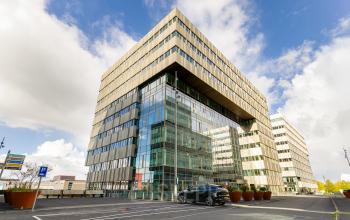Modern office building at Herikerbergweg 288 in Amsterdam South East, featuring glass facade and available parking spaces for office space rental.