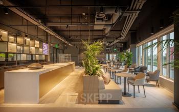 Modern furnished lounge area at Herikerbergweg 288, Amsterdam South East, featuring a stylish bar and seating options, perfect for business meetings or relaxation. Ideal office space rental with contemporary amenities.