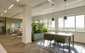 Bright office space with a mix of workstations and a seating area, located at Herikerbergweg 288, Amsterdam South East, ideal for office space rental.