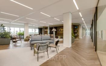 Spacious office at Herikerbergweg 288, Amsterdam South East, featuring modern furnishings and hardwood flooring; a perfect office space rental with open floorplan for workspaces.