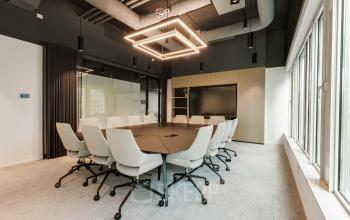 Modern conference room at Herikerbergweg 288, Amsterdam South East, offering office space rental with sleek chairs and ample lighting.