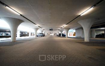 Covered parking area at Herikerbergweg 288, located in Amsterdam South East, showcasing ample space for vehicles in a modern office setting. Ideal for office space rental.