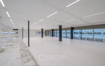 Spacious office interior at Herikerbergweg 288, Amsterdam South East, ideal for office space rental with large windows and an open layout.