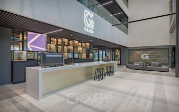 Modern and inviting reception area at Herikerbergweg 288, Amsterdam South East, featuring a sleek desk and a comfortable seating area. Ideal for impressing clients in office space rental.