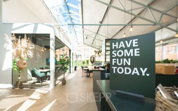 Bright, airy office space rental with glass roof, greenery, and modern furnishings at Luttenbergweg 8. Ideal office to rent in Amsterdam South East for productive work.