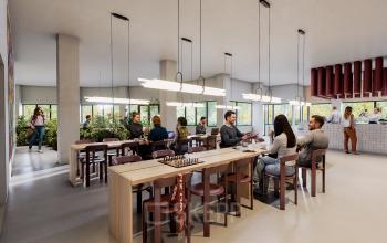 Spacious and modern workspace at Luttenbergweg 8, Amsterdam South East. People are engaged in business discussions around large wooden tables in a well-lit, furnished environment, ideal for office space rental.