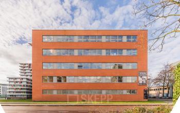 Exterior view of a brick office building at Paasheuvelweg 20, Amsterdam South East, highlighting available office space rental options.