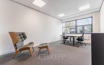 Bright office space with modern furniture, featuring a desk and chairs, located at Paasheuvelweg 20 in Amsterdam South East, ideal for office space rental.
