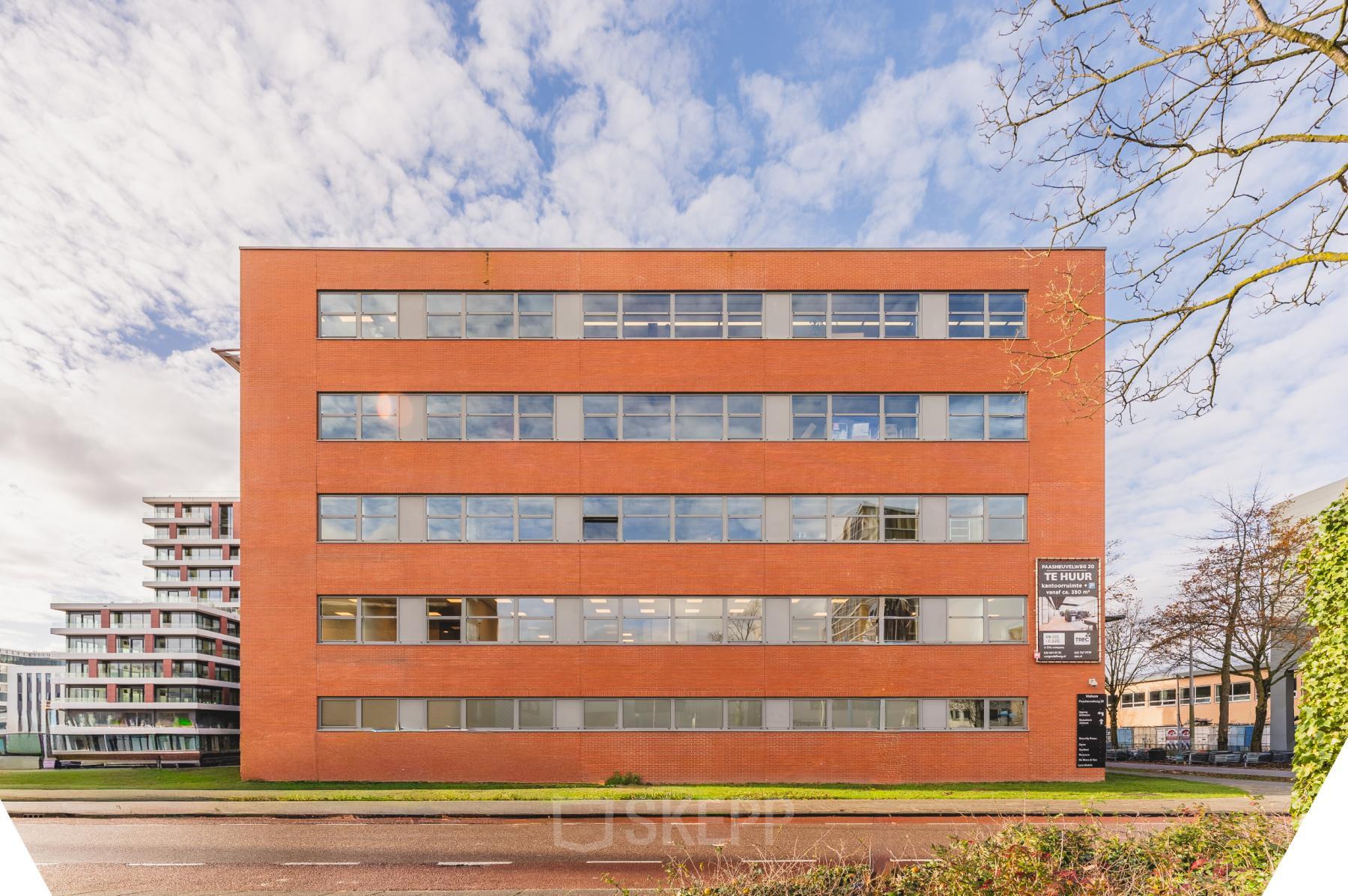 Exterior view of a brick office building at Paasheuvelweg 20, Amsterdam South East, highlighting available office space rental options.