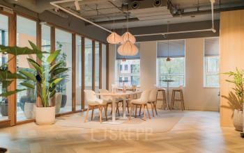 Bright, furnished office space in Amsterdam South East with modern furniture and large windows, ideal for rent office space needs.