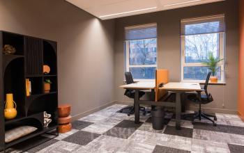 Bright office space with two desks and chairs, natural light from large windows, and contemporary decor at Hullenbergweg 109-135 in Amsterdam South East. Ideal for office space rental.
