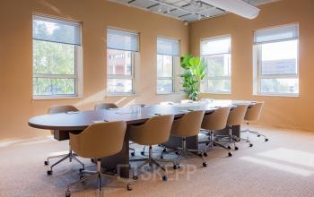 Bright office space with large windows and a meeting table in Amsterdam South East, ideal for rent office space seekers wanting a productive environment.