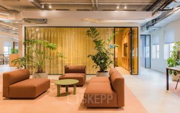 Modern office space at Hullenbergweg 109-135, Amsterdam South East, featuring contemporary seating and large indoor plants, available for office space rental.